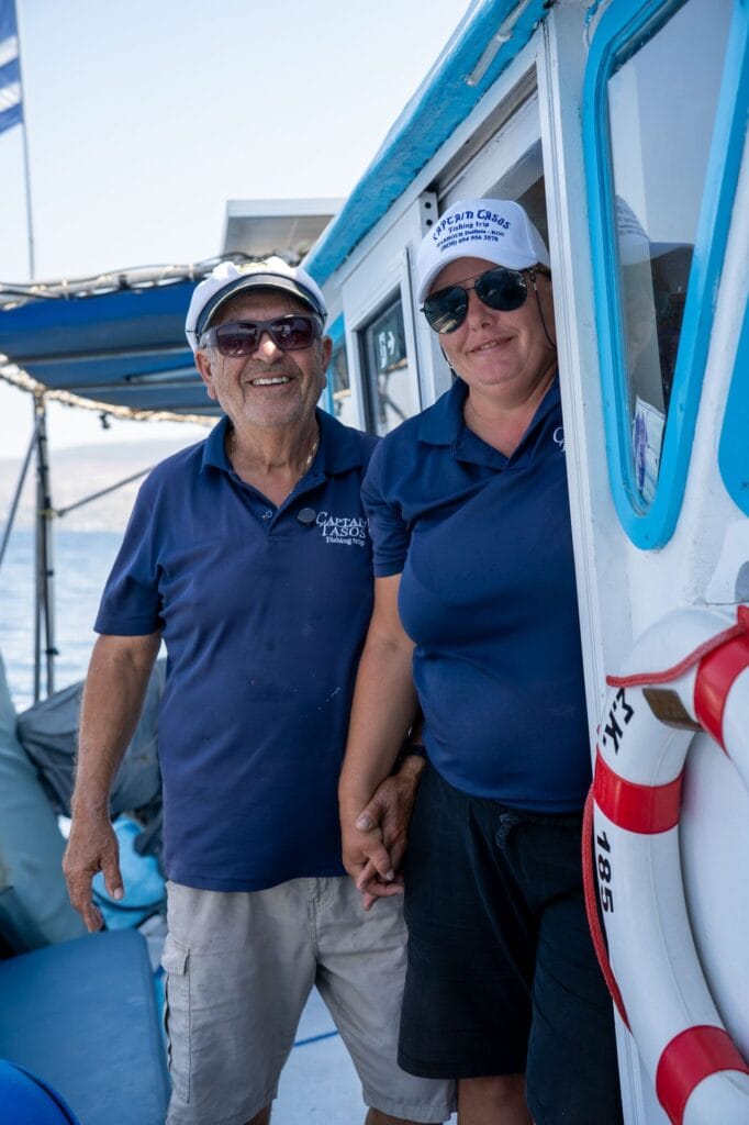 Alex and Mariana in Captain Tasos shirts on board their fishing boat in Kos