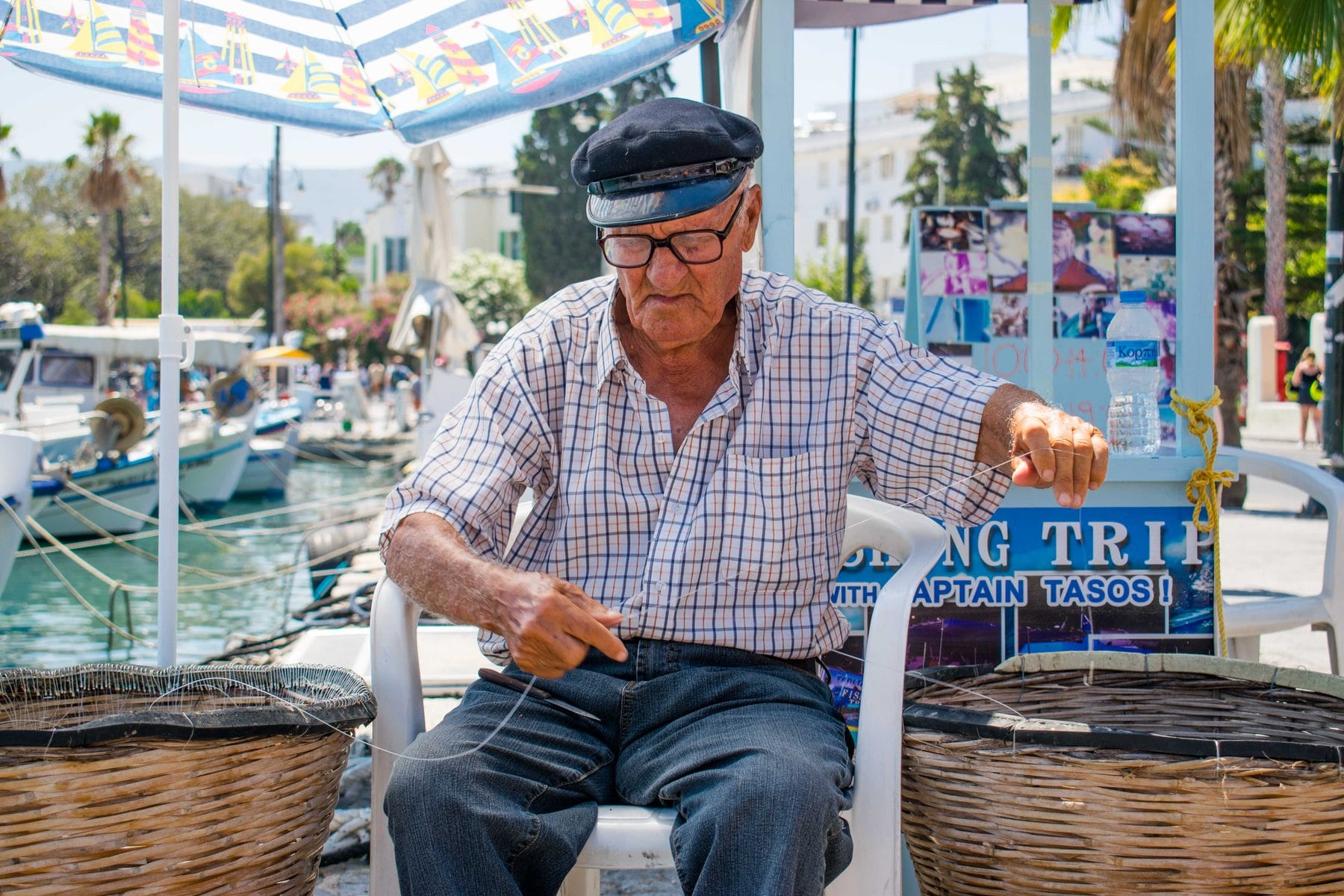 Captain Tasos mending fishing line on the quay in Kos Harbour