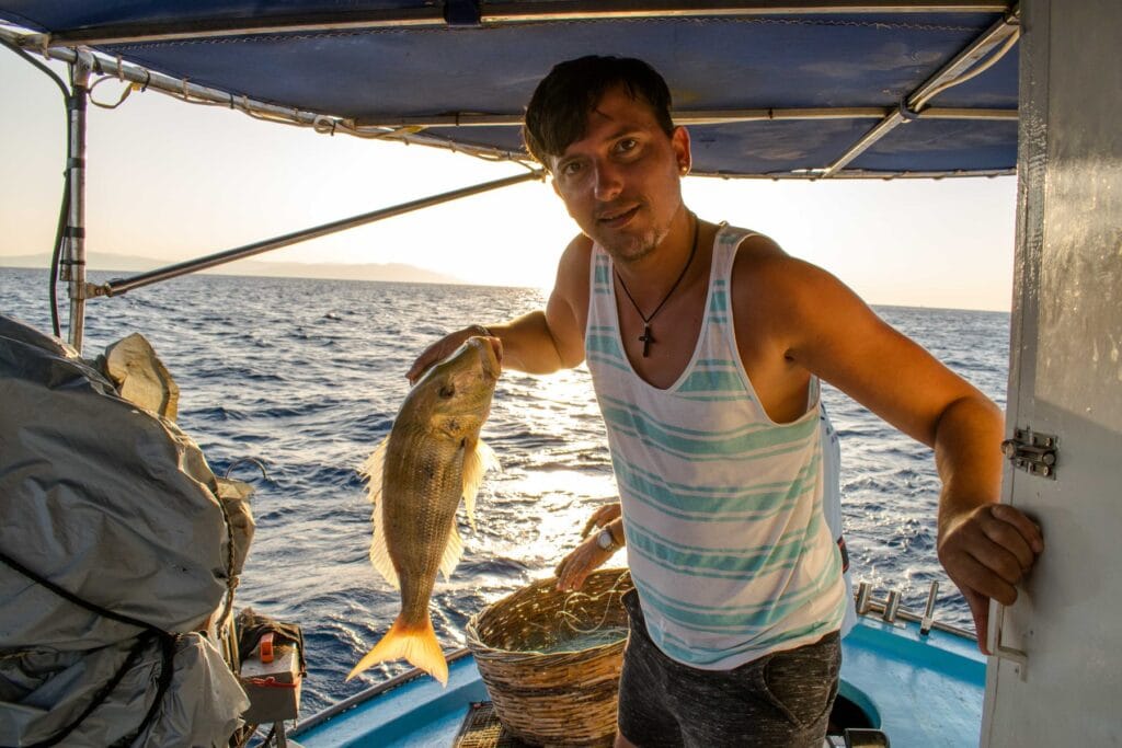 A guest holding up a fish caught on a Captain Tasos fishing trip