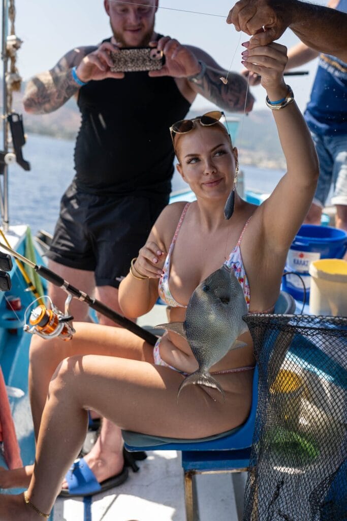 A guest holding a fish caught on a Captain Tasos fishing trip in Kos