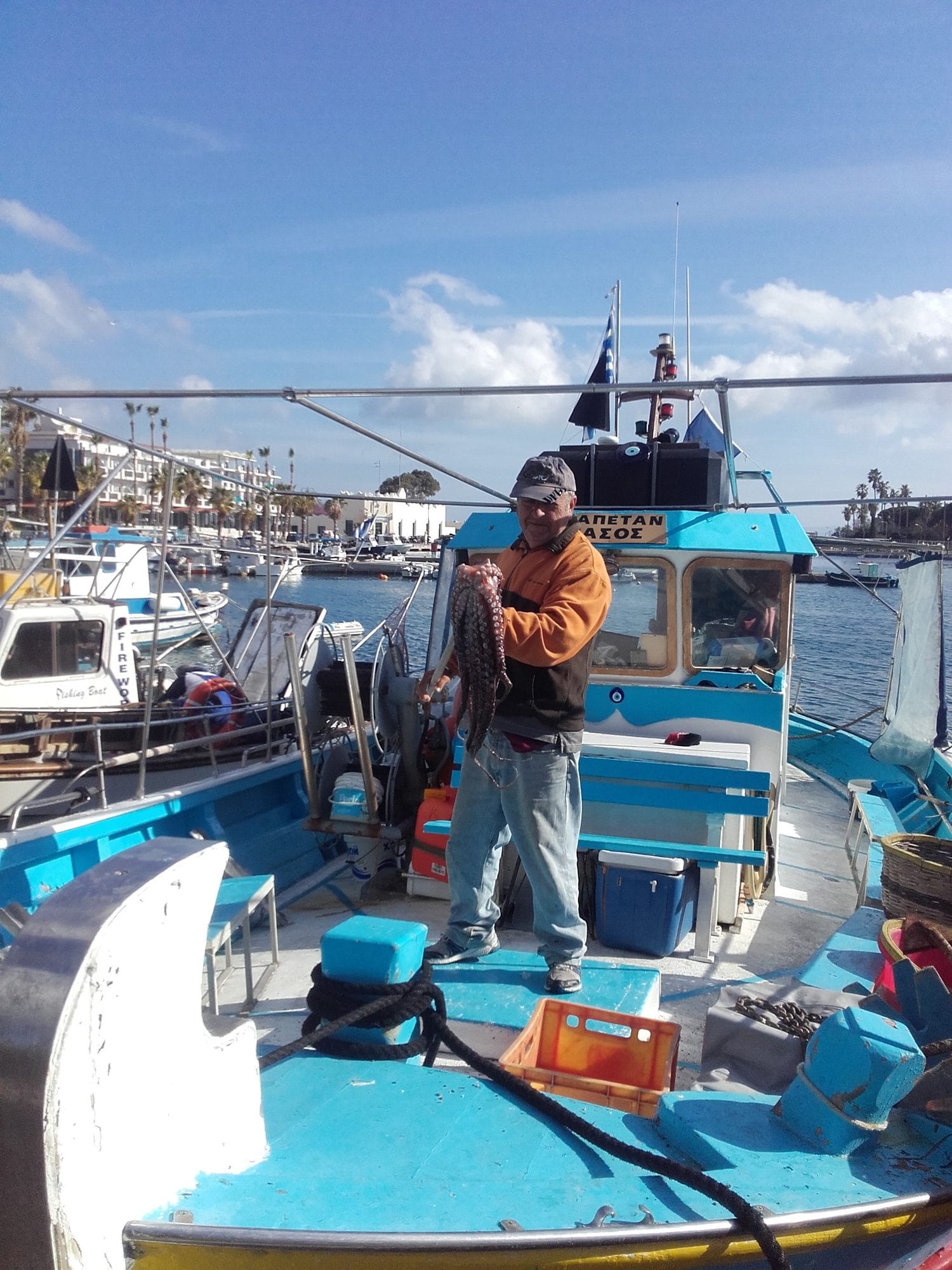 March 2017. Alex with an octopus, the boat tied up in Kos Harbour.